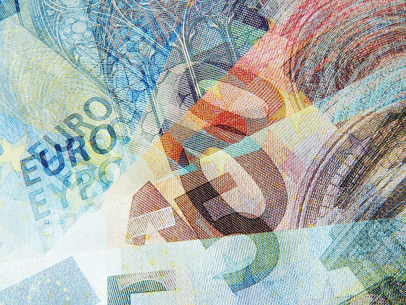 Eine farbenfrohe, künstlerische Überlagerung mehrerer Euro-Geldscheine verschiedener Stückelungen, bei der Sicherheitsmerkmale, Zahlen und architektonische Motive ineinander verschwimmen.