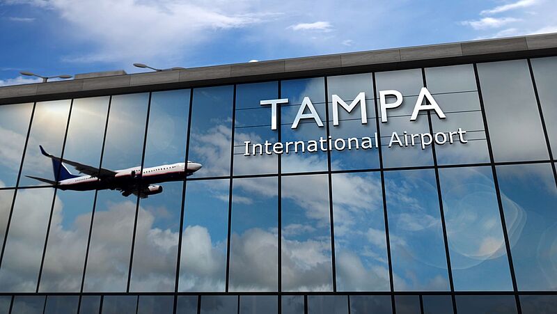 Außenansicht des Flughafens Tampa, in der Glasfassade spiegelt sich ein Flugzeug