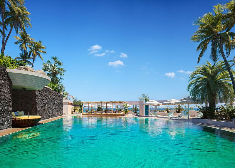 Traumhafter Pool im Iberostar Selection Fuerteventura Palace auf den Kanaren mit Palmen, Sonnenliegen und Meerblick unter blauem Himmel