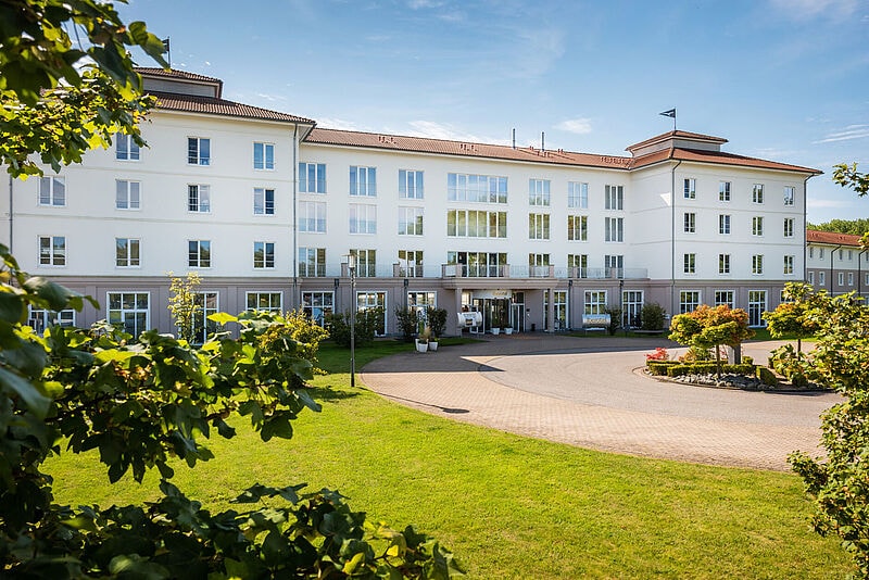 Großes Hotelgebäude mit Wiese im Vordergrund
