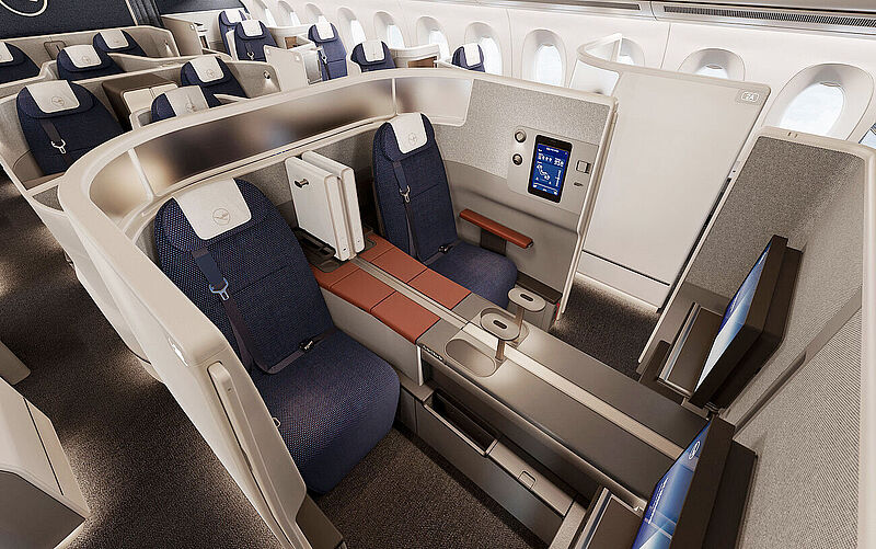 Doppelsuite in der neuen Allegris-Business-Class von Lufthansa im Airbus A350 mit blauem Polster, Touchscreen-Display und Privacy-Trennwand in beige-grauer Umgebung.