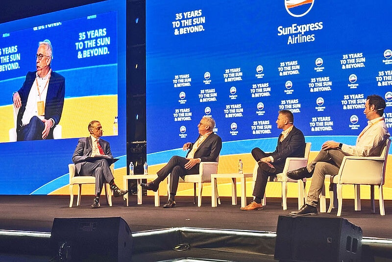 Männer bei einer Podiumsdiskussion sitzend auf einer Bühne