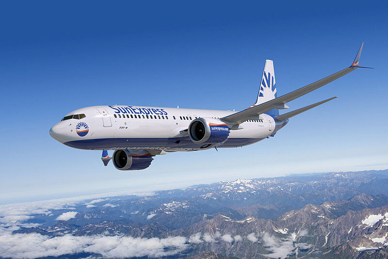 Eine Maschine von Sun Express fliegt über ein Gebirge