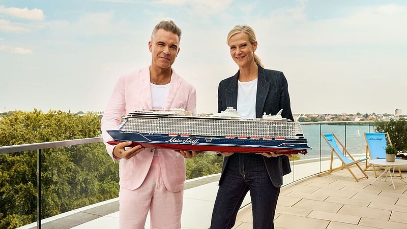 Robbie Williams und Wybcke Meier in den Händen ein Modell der Mein Schiff Relax