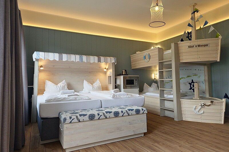 Ein Hotelsimmer im TUI Kids Club an der Nordsee mit Doppelbett und Stockbett in Schiffform