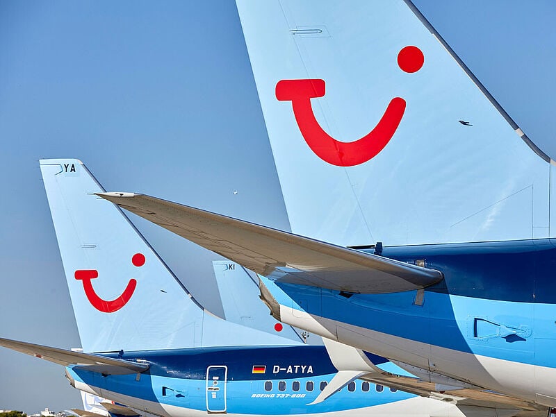 Nahaufnahme hellblauer TUI-Flieger, die an einem Airport in Parkposition stehen.