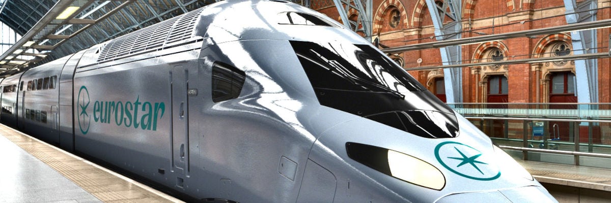 Ein moderner Eurostar Hochgeschwindigkeitszug steht am Bahnsteig eines historischen Bahnhofs in Europa. Das silberne Zugdesign und die auffällige Eurostar-Beschriftung sind deutlich zu erkennen. Im Hintergrund ist die imposante Architektur des Bahnhofs mit Ziegelwänden und Stahlträgern zu sehen.