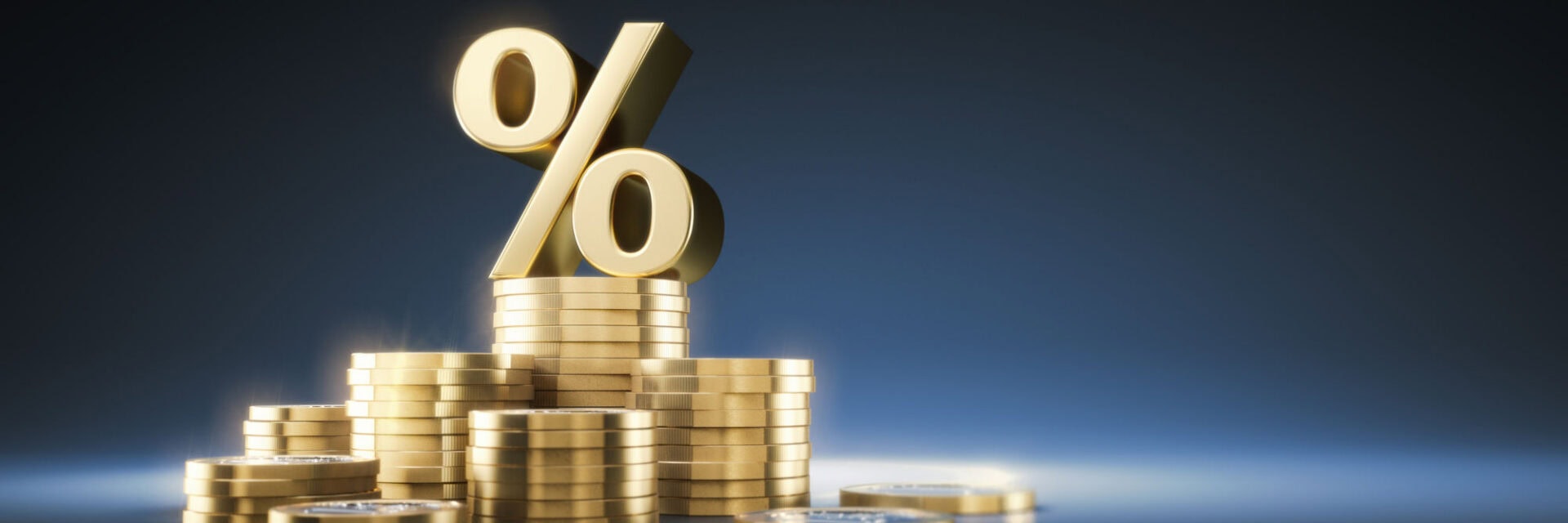 Goldenes Prozentzeichen auf übereinandergestapelten Goldmünzen vor dunkelblauem Hintergrund, symbolisiert Zinsen, Rendite oder Cashback im Finanz und Geldanlagekontext.