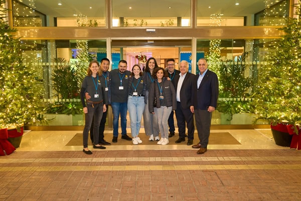 Eine Gruppe von Menschen steht vor einem Gebäude, das weihnachtlich geschmückt ist.