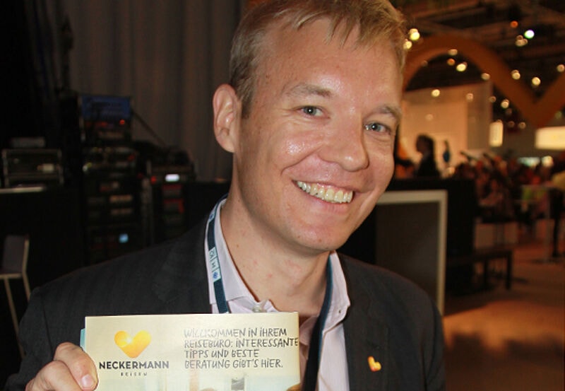 Vorwürfe entkräften: Cook-Vertriebschef Carsten Seeliger zeigt auf der Veranstaltung Travelconnexion die Reisebüro-Anzeige im Katalog.