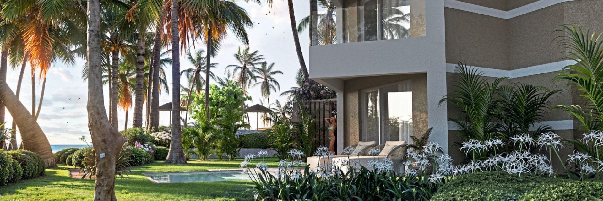 Das Bild zeigt eine luxuriöse Hotelanlage in Punta Cana mit modernen Zimmern und einer Terrasse, umgeben von tropischen Palmen und gepflegtem Garten. Im Hintergrund ist ein Poolbereich zu sehen, der Erholung und Exklusivität am Meer verspricht. Die Szene strahlt Urlaubsfeeling und Karibik-Flair aus