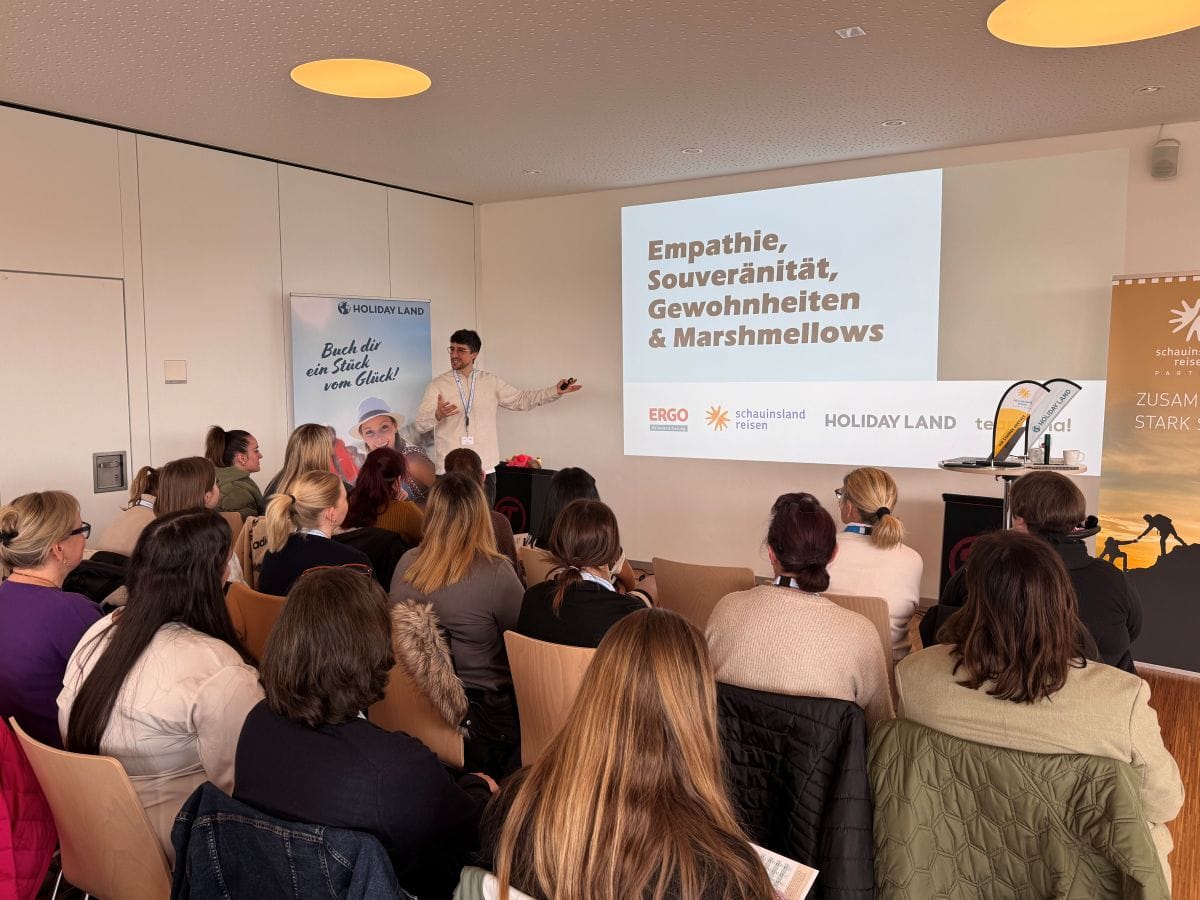 Trainer hält einen Vortrag vor Nachwuchskräften aus Reisebüros bei einer Schulungsveranstaltung von Alpha Reisebüro Partner und Holiday Land.