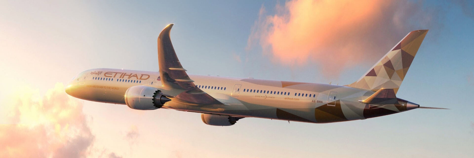 260127-etihad-flugzeug-in-der-luft Ein modernes Etihad-Flugzeug, eine Boeing 787 Dreamliner, fliegt hoch über den Wolken bei Sonnenuntergang. Das Passagierflugzeug trägt das charakteristische goldene Design der Fluggesellschaft und ist am blauen Himmel deutlich zu erkennen.