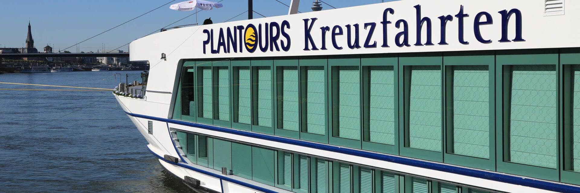 Zu sehen ist der vordere Teil des modernen Flusskreuzfahrtschiffes Lady Diletta. Auf der weißen Schiffswand prangt in großen Buchstaben der Veranstaltername Plantours Kreuzfahrten.