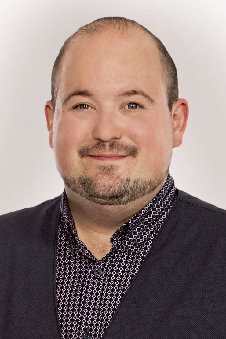 Ein Mann mit lichtem Haar und Bart lächelt in die Kamera