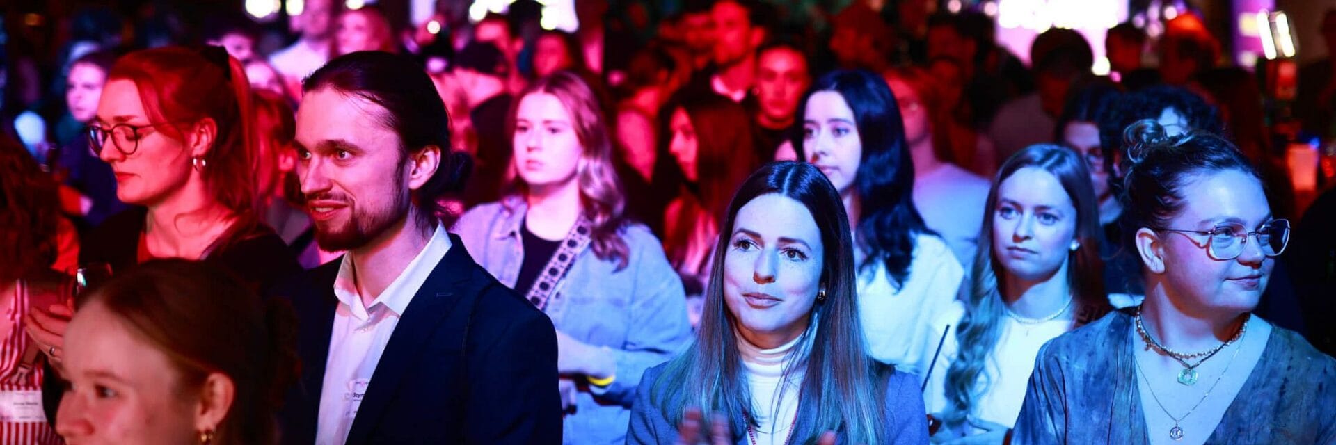 Junge Menschen bei einer Abendveranstaltung in einer Halle