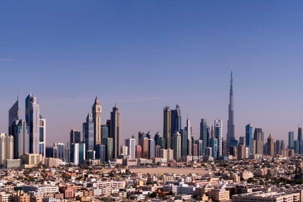 Panorama der Skyline von Dubai mit dem Burj Khalifa als höchstem Gebäude, umgeben von modernen Wolkenkratzern und Wohnhäusern, unter klarem, blauem Himmel. Das Foto ist schon älter, dennoch zeigt die Aufnahme die beeindruckende Architektur und den Rekordbau der Stadt.