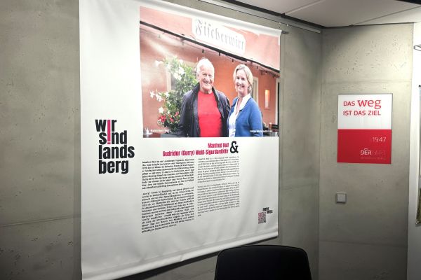 Ein großes Plakat mit der Aufschrift "Wir sind Landsberg" zeigt ein Foto von zwei Menschen und dazu einen Beschreibungstext.
