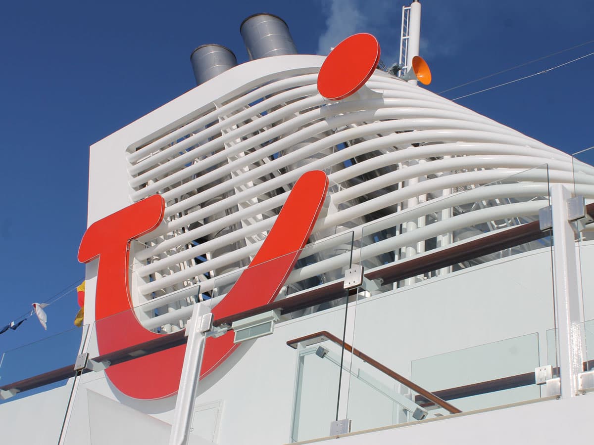 Auf dem weißen Schornstein eines Kreuzfahrtschiffes prangt das rote TUI-Logo.