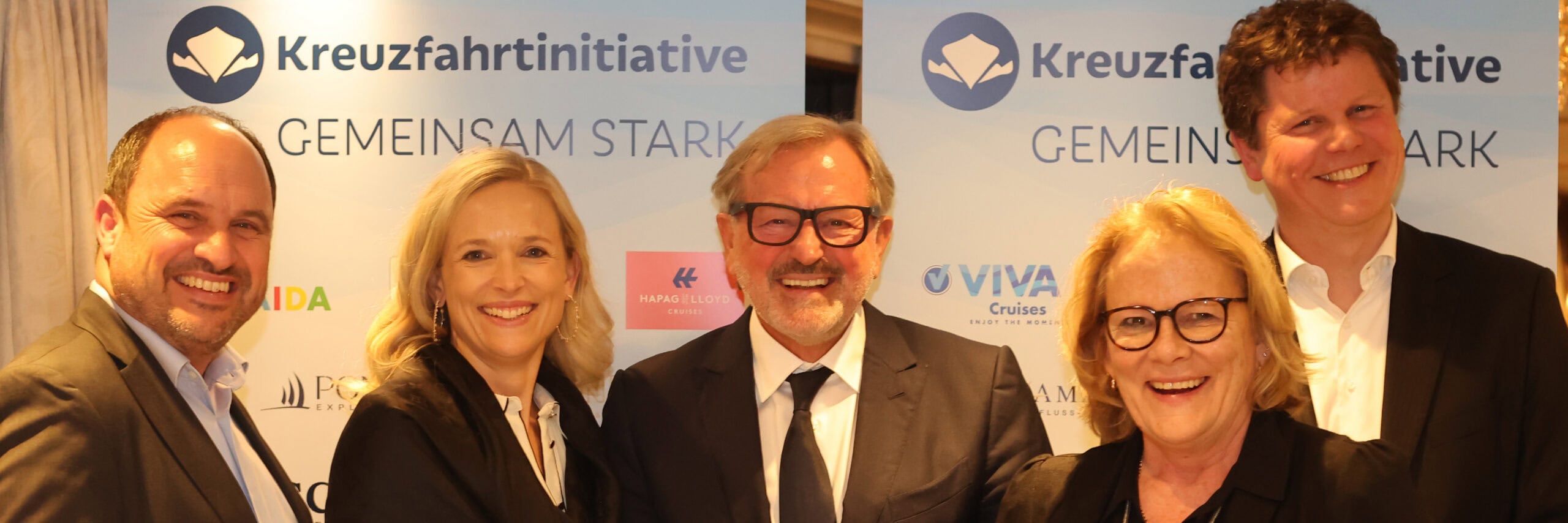 Drei Männer und zwei Frauen stehen bei einer Preisverleihung auf einem Flussschiff.