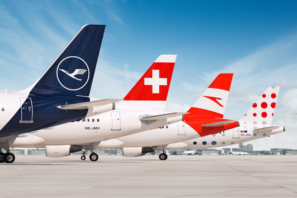 Mehrere Flugzeuge verschiedener europäischer Airlines stehen hintereinander auf dem Rollfeld eines Flughafens, deutlich erkennbar sind die Leitwerke von Lufthansa, Swiss, Austrian Airlines und Brussels Airlines vor blauem Himmel.