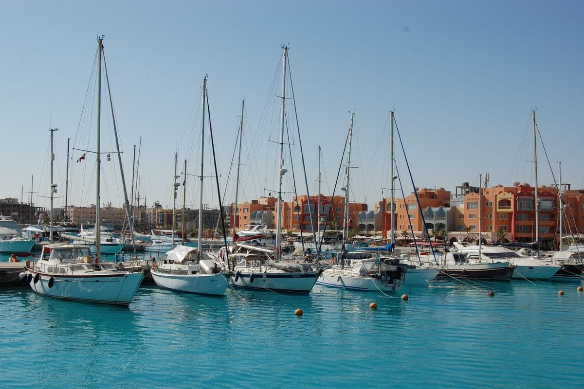 Yachthafen in Hurghada mit Segelbooten und bunten Gebäuden im Hintergrund