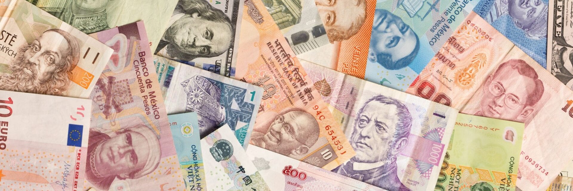 Geldscheine verschiedener Währungen liegen nebeneinander.