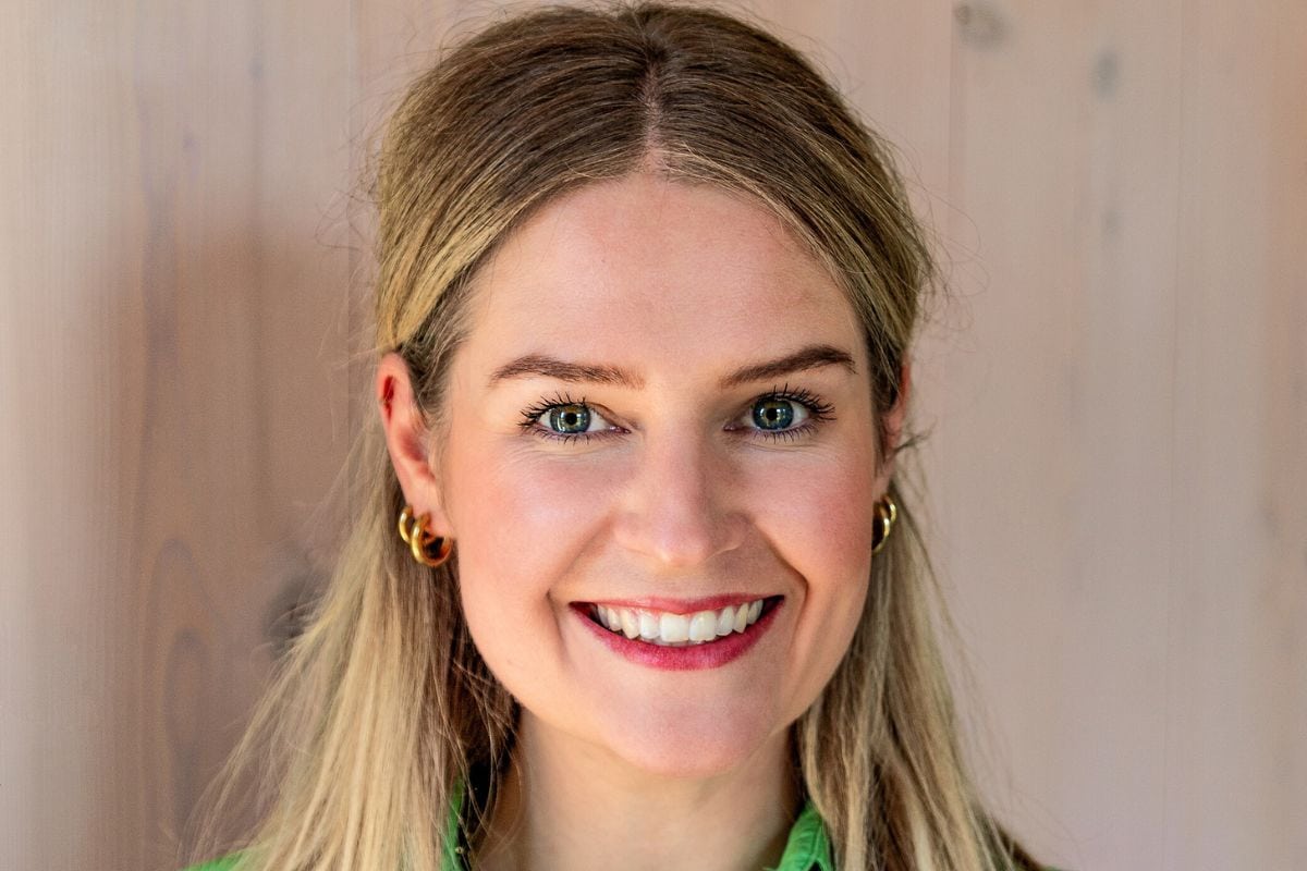 Das Bild zeigt eine lächelnde Frau mit hellem Haar und grünen Augen, die direkt in die Kamera blickt. Sie trägt dezenten Schmuck und wirkt freundlich und professionell – passend zu einem Business- oder Pressekontext.