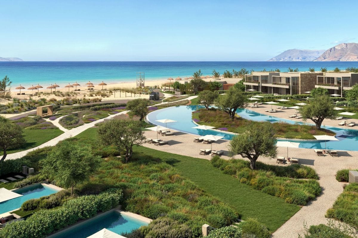 Das Foto zeigt das luxuriöse Ikos Kissamos Resort auf Kreta direkt am Sandstrand mit türkisblauem Meer, großzügiger Poollandschaft, modernen Gebäuden und grünen Gartenanlagen.