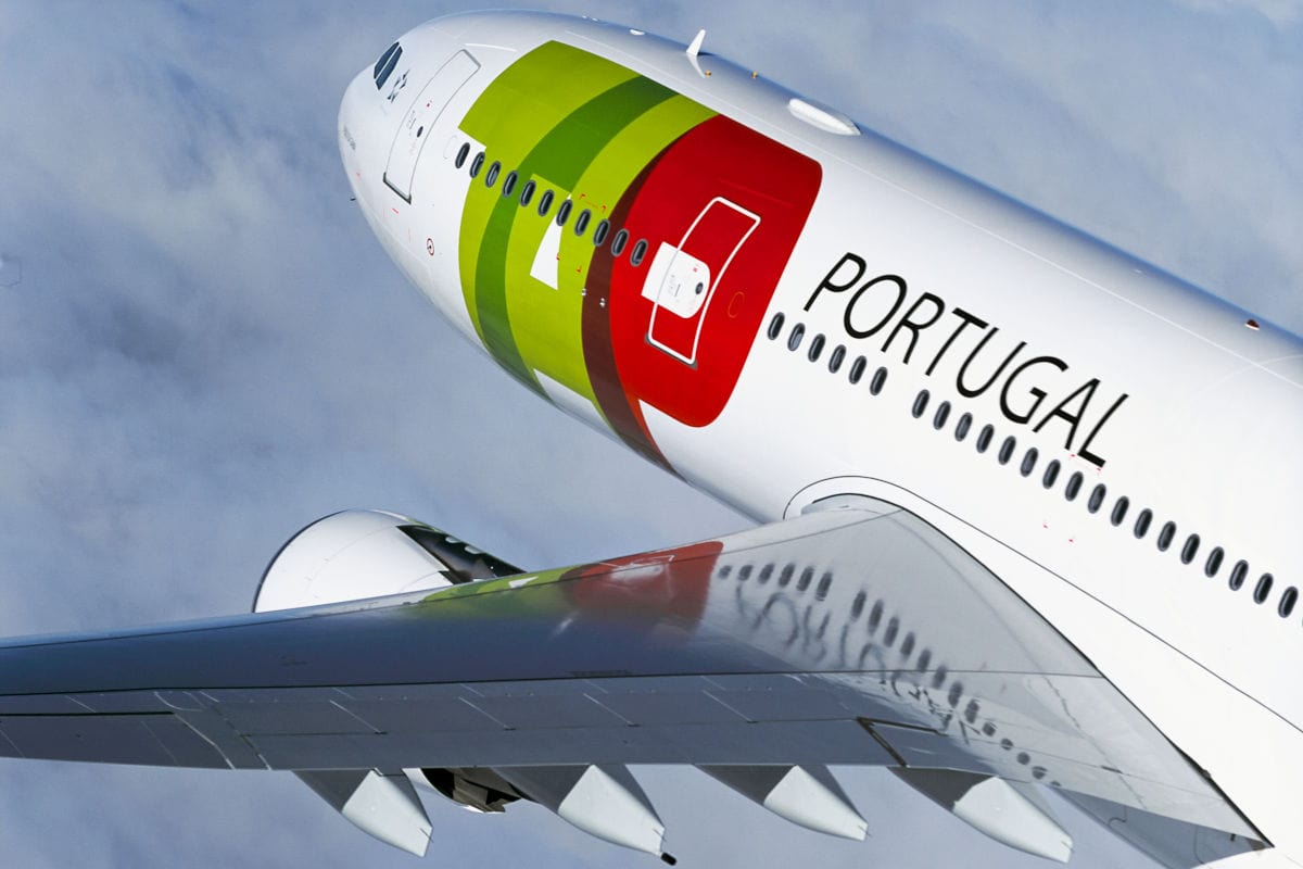 Auf dem Bild ist ein modernes Passagierflugzeug der Fluggesellschaft TAP Air Portugal im Steigflug am Himmel zu sehen, deutlich erkennbar an der auffälligen Bemalung in Grün, Rot und Weiß. Das Flugzeug trägt den Schriftzug "Portugal".