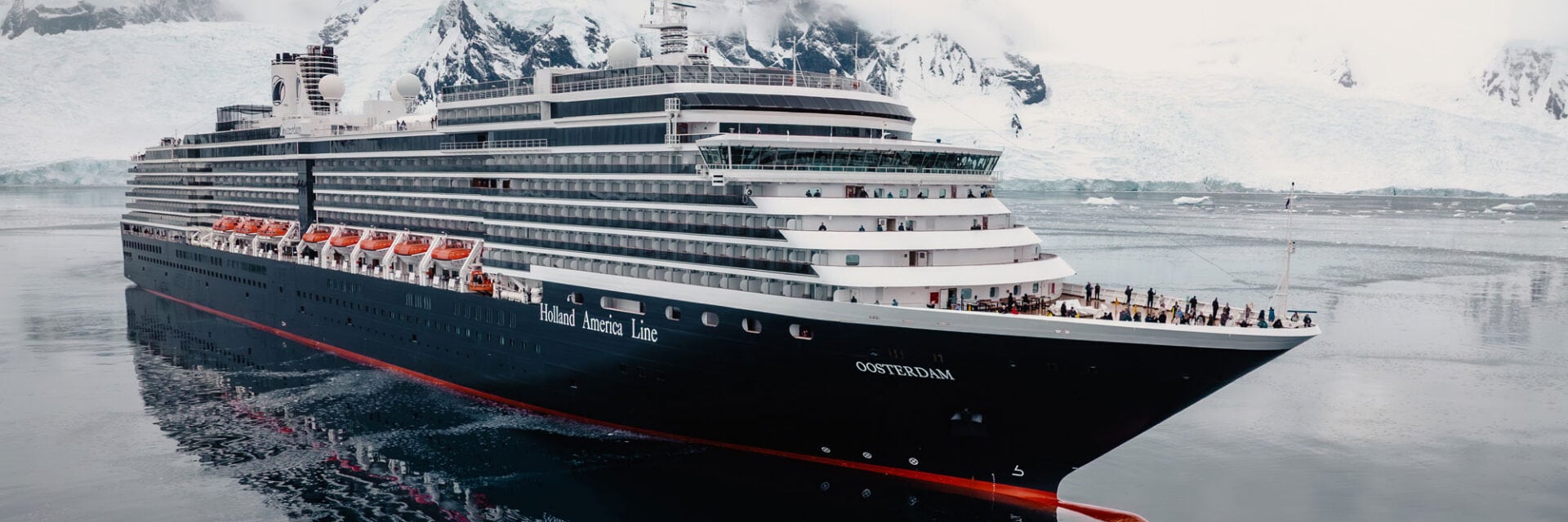 Das Kreuzfahrtschiff Oosterdam mit schwarzem Rumpf auf See. Das Meer ist dunkelblau.