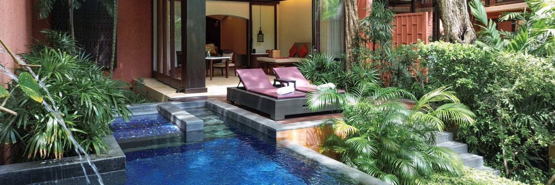 Außenansicht von der Pool-Suite mit privatem Pool im Vordergrund, eine Terrasse mir zwei Liegen, im Hintergrund das Zimmer, umgeben von tropischen Pflanzen