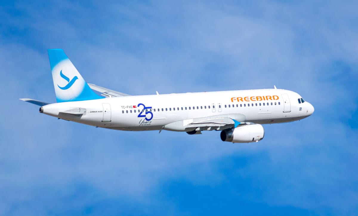 Ein Freebird Airlines Flugzeug vom Typ Airbus A320 fliegt bei blauem Himmel, das Logo und der Schriftzug „25 Years“ sind auf dem Rumpf sichtbar. Das Passagierflugzeug hebt sich durch seine moderne Lackierung und das auffällige Freebird-Branding hervor.