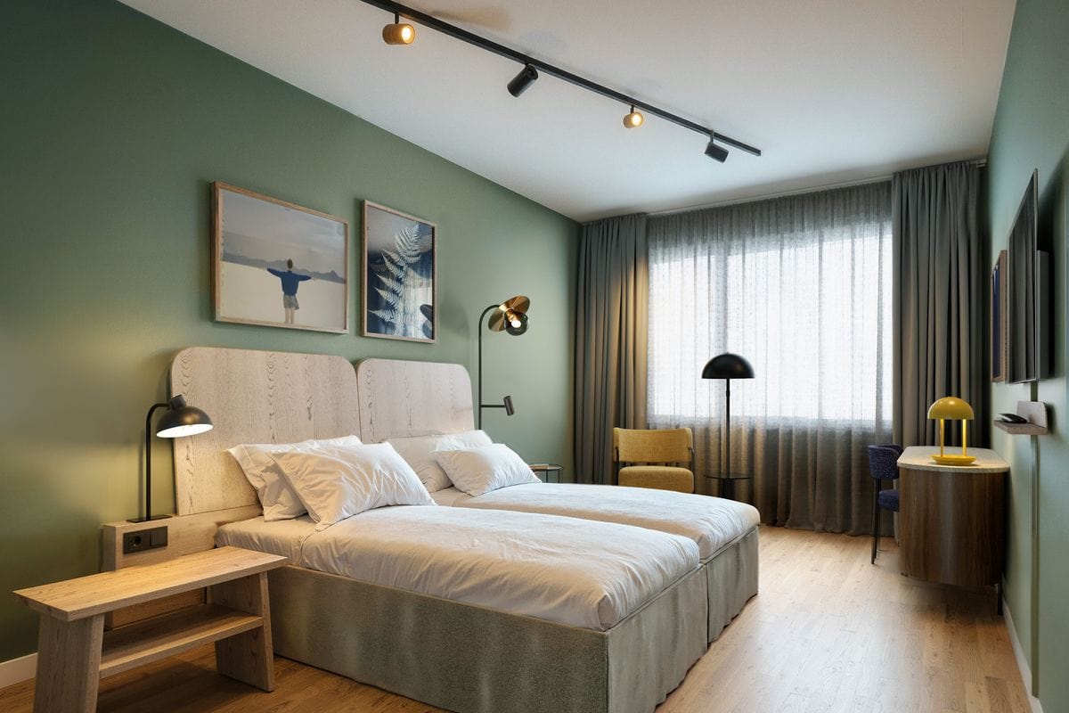 Modernes Hotelzimmer mit grüner Wand, zwei Einzelbetten, hellem Holzmobiliar, Schreibtisch, Sessel und großer Fensterfront mit Vorhängen.