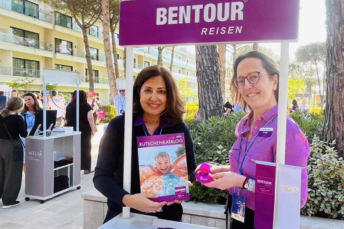 Zwei Frauen stehen an einem Stand von Bentour Reisen. Die eine hält einen Rutschenkatalog in den Händen, die andere eine lilafarbene Badeente