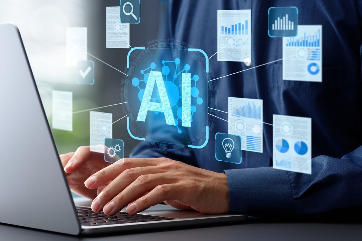 Person arbeitet an einem Laptop, darüber eingeblendete Symbole und Grafiken rund um künstliche Intelligenz, Datenanalyse und digitale Prozesse.