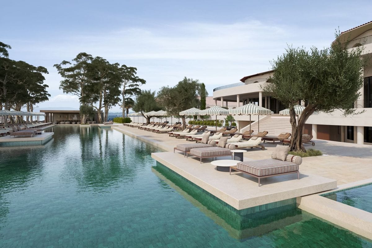 Das Foto zeigt den großzügigen Außenpool des Conrad Corfu Resorts auf der griechischen Insel Korfu, umgeben von Liegestühlen und mediterraner Vegetation. Im Hintergrund erstreckt sich der exklusive Privatstrand.