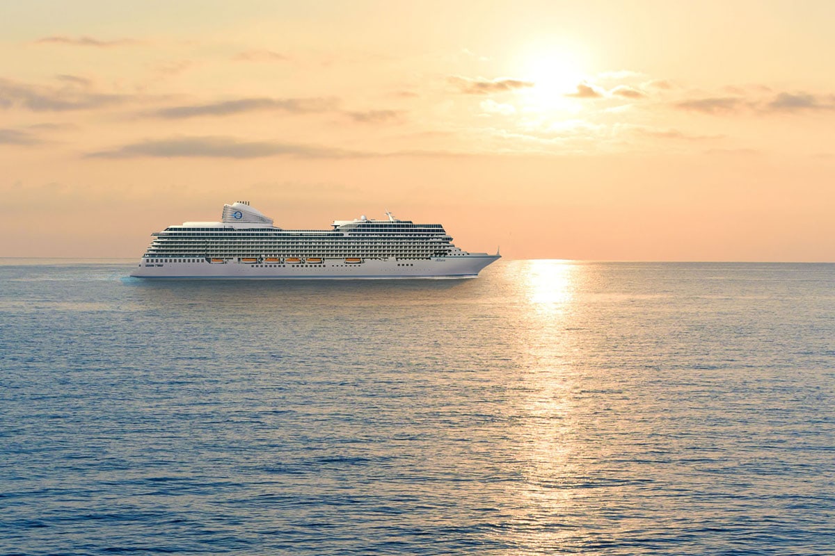 Ein luxuriöses Kreuzfahrtschiff der Oceania Cruises fährt auf ruhigem Meer bei Sonnenuntergang, das goldene Licht spiegelt sich auf dem Wasser. Das Bild vermittelt Urlaubsfeeling und Exklusivität beim Kreuzfahrturlaub.