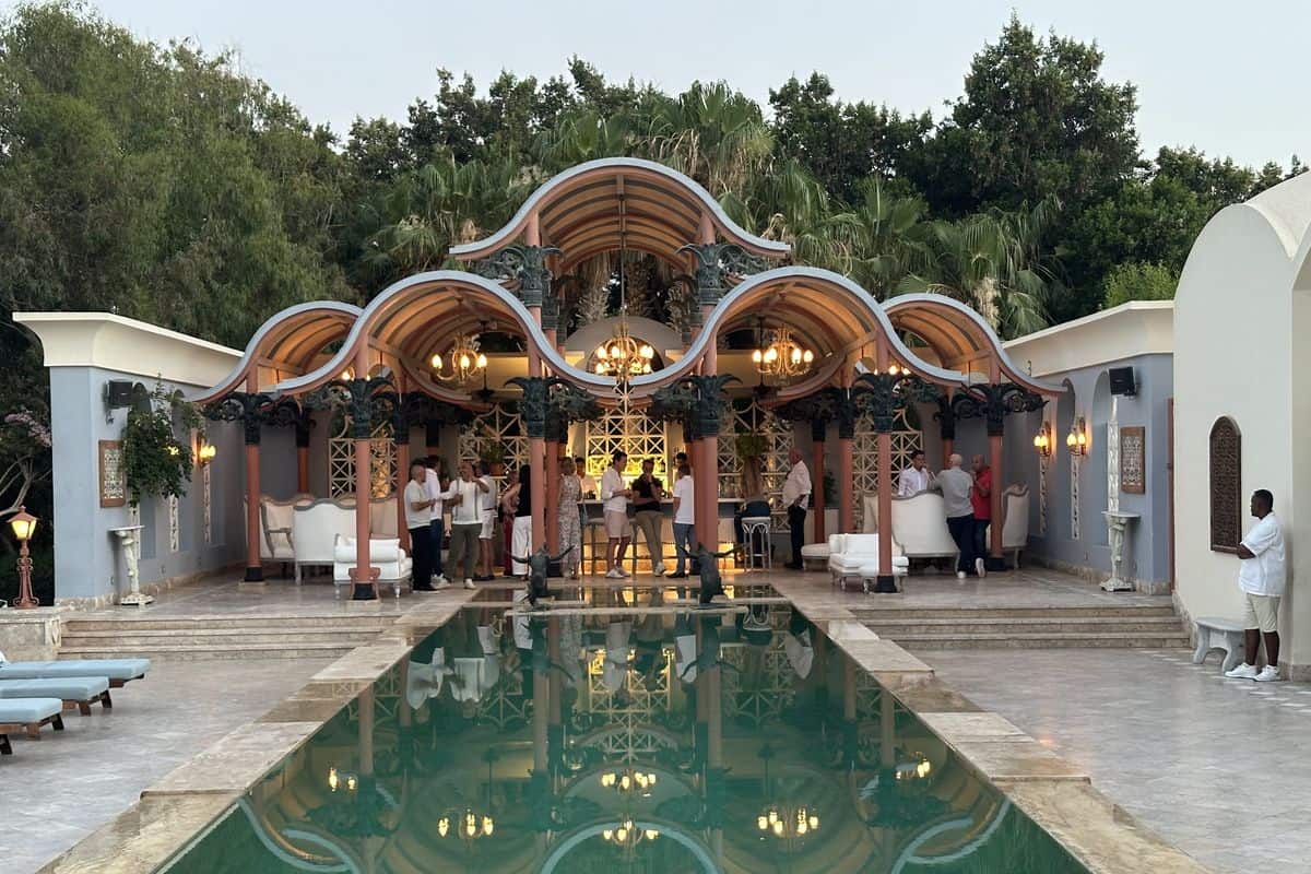 Elegante Außenansicht eines Veranstaltungsortes mit einem Pool, stilvollen Möbeln und einer begrünten Umgebung, ideal für gesellschaftliche Zusammenkünfte.