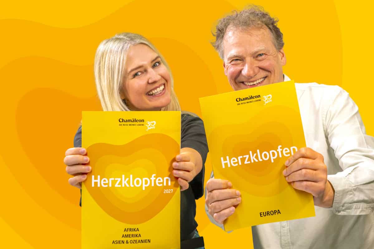 Zwei Personen halten jeweils ein gelbes Heft mit dem Titel 'Herzklopfen' in den Händen, vor einem gelben Hintergrund.