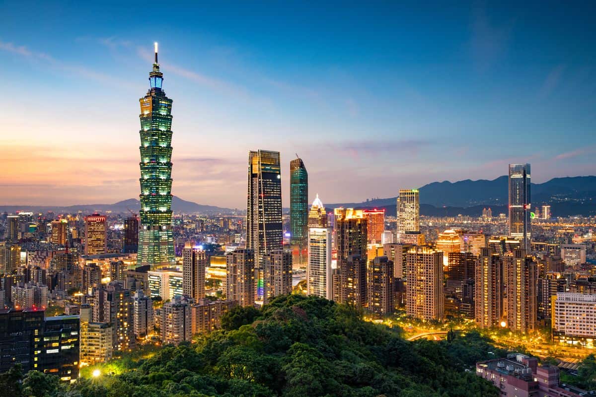 Panoramablick auf die Skyline von Taipeh bei Sonnenuntergang, mit dem Taipei 101 als markantem Wahrzeichen und modernen Wolkenkratzern.