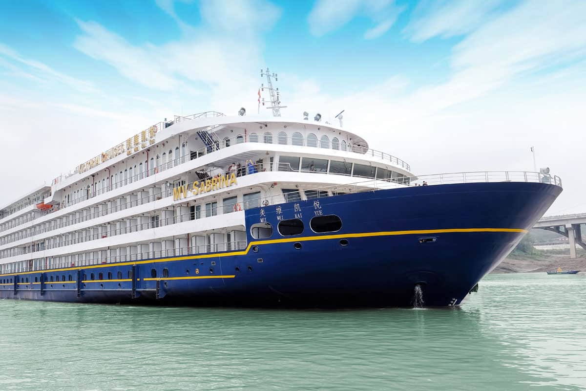 Das Flusskreuzfahrtschiff Viktoria Sabrina liegt im Wasser, umgeben von einer ruhigen Landschaft und einem klaren Himmel.