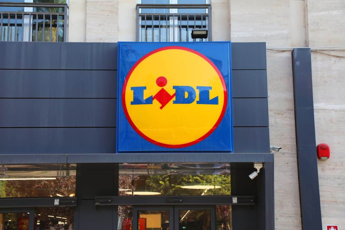 Das Bild zeigt das Logo von Lidl an der Fassade eines Geschäfts, umgeben von modernen architektonischen Elementen.