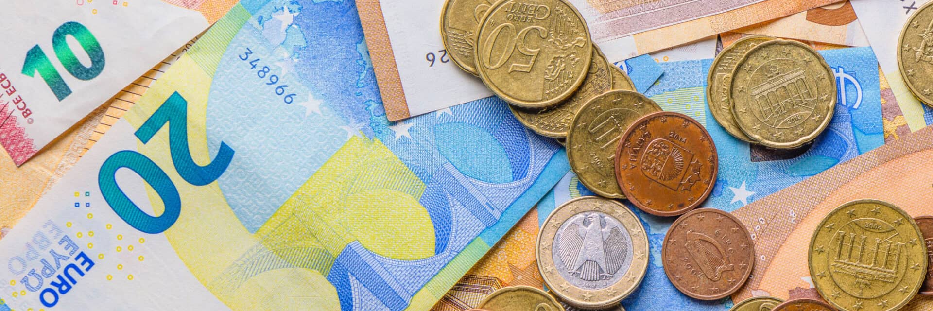olimar-provisionen Ein Haufen von Euro-Banknoten und Münzen in verschiedenen Stückelungen, die auf einem Tisch verstreut liegen.