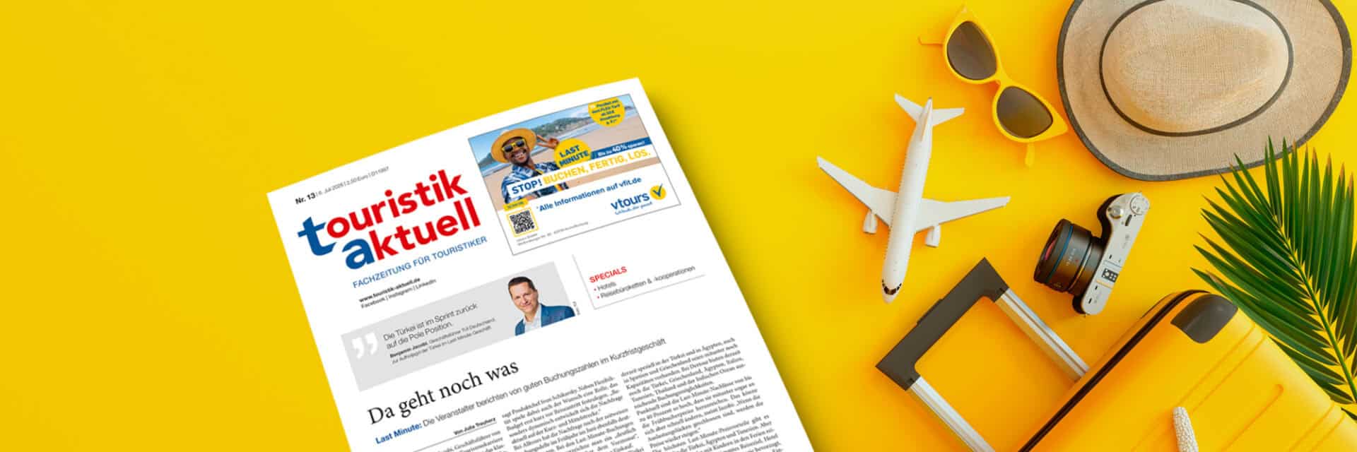 ta-header-13-26-onurdongel-neu Ein Reisemagazin liegt auf einem gelben Hintergrund, umgeben von einem Koffer, einer Kamera, einer Flugzeugminiatur, Sonnenbrille und einem Hut.