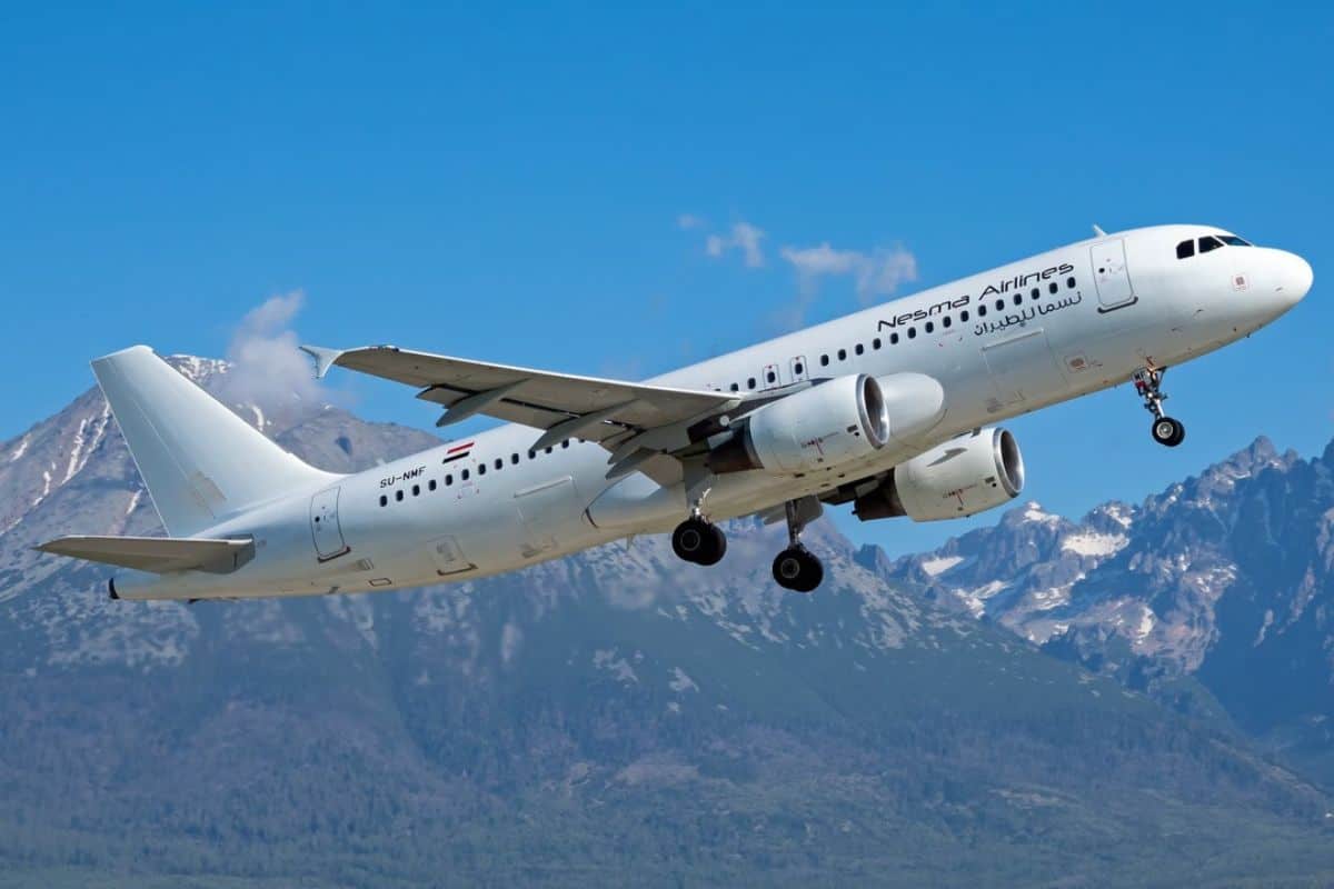 Ein weißes Passagierflugzeug der Fluggesellschaft Nesma Airlines hebt vor einer Kulisse aus schneebedeckten Bergen bei klarem, blauem Himmel in die Luft ab.