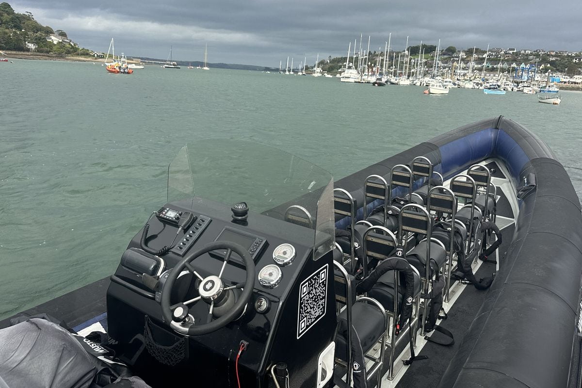 Blick vom Steuerstand eines Festrumpfschlauchbootes auf eine Bucht mit zahlreichen vor Anker liegenden Segelbooten und Motorbooten unter bewölktem Himmel.