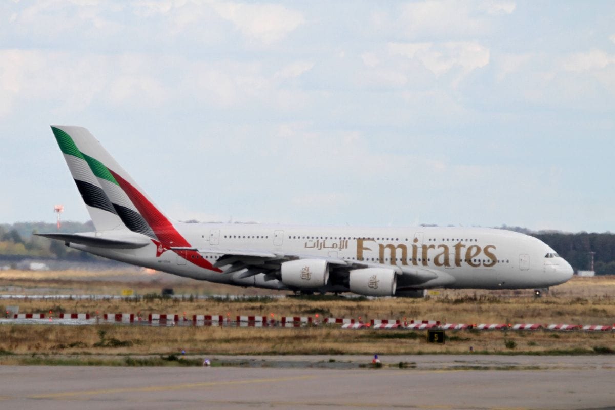 Ein großes Passagierflugzeug vom Typ Airbus A380 der Fluggesellschaft Emirates rollt bei Tageslicht über eine Rollbahn an einem internationalen Flughafen.