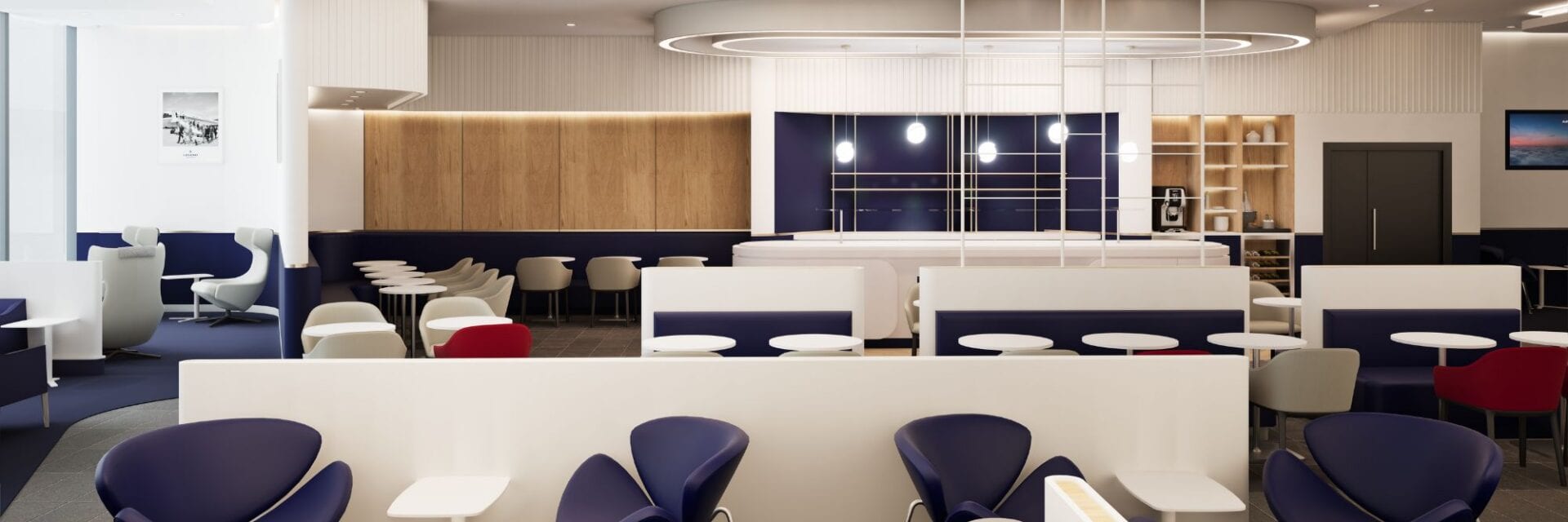 air-france-terminal-3-lounge-frankfurt Innenansicht einer modernen Lounge mit dunkelblauen Sesseln, weißen Trennwänden, einer zentralen Bar und hellen Holzelementen in einem offenen Raumkonzept.