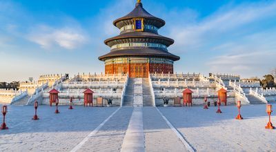 Der kreisförmige Himmelstempel in Peking mit seinem dreistufigen blauen Dach steht auf einer breiten, weißen Steinterrasse vor einem klaren, blauen Himmel.